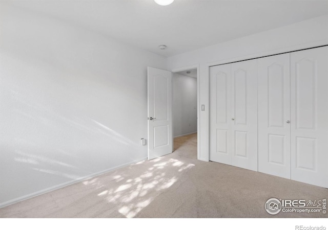 unfurnished bedroom with carpet and a closet
