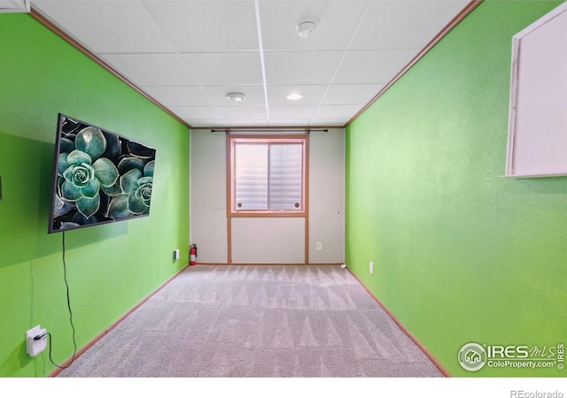 carpeted spare room with baseboards and a paneled ceiling