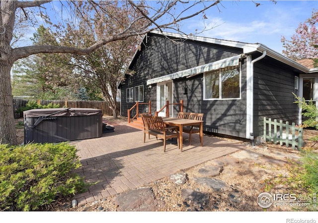 exterior space with a fenced backyard, a patio, a hot tub, and outdoor dining space