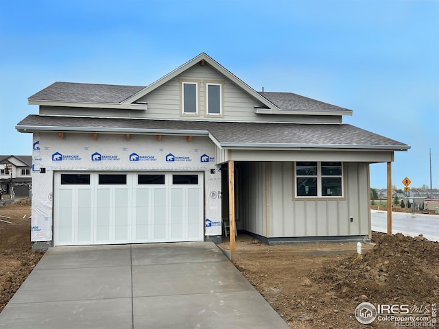 view of front of home with a garage, concrete driveway, a shingled roof, and board and batten siding