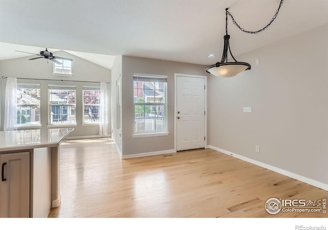 interior space with lofted ceiling, baseboards, light wood-type flooring, recessed lighting, and a ceiling fan