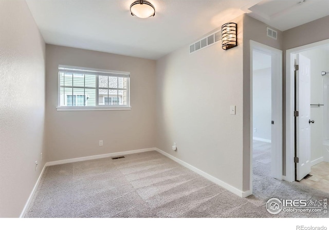 unfurnished room with carpet floors, baseboards, and visible vents