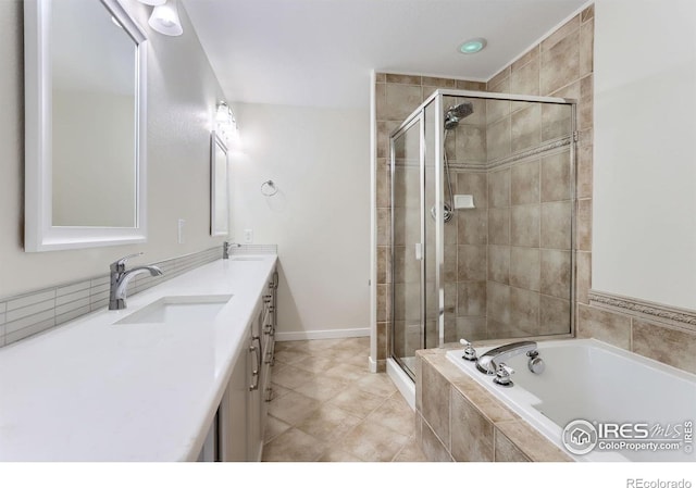 bathroom featuring double vanity, a sink, a bath, and a shower stall