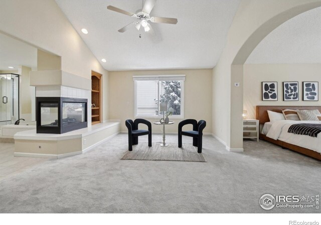 bedroom with baseboards, carpet flooring, arched walkways, and lofted ceiling