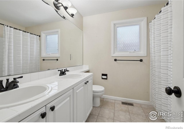 bathroom with toilet, baseboards, visible vents, and a sink