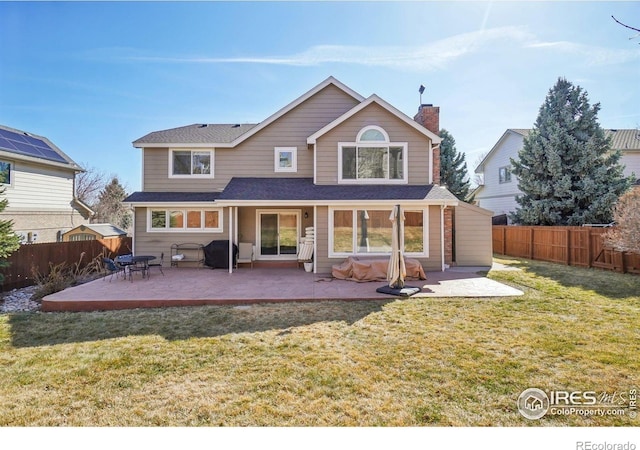 rear view of house with a lawn, a patio, and a fenced backyard