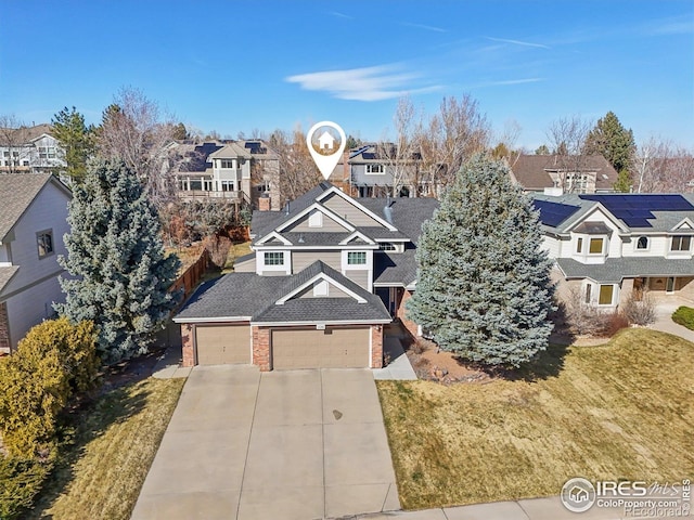view of front of home featuring brick siding, a front yard, driveway, and a residential view