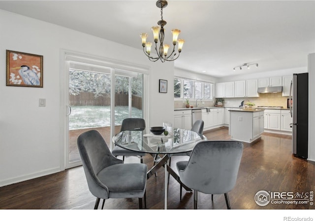 dining room with baseboards, dark wood-style flooring, and a notable chandelier