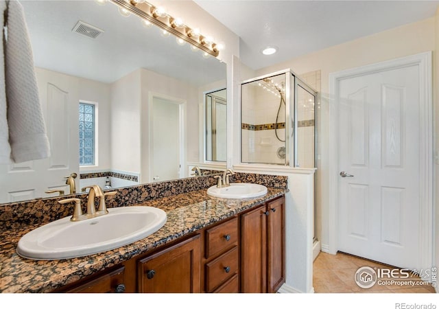 full bathroom with visible vents, a shower stall, a sink, and tile patterned flooring