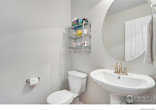 half bathroom with toilet and a sink