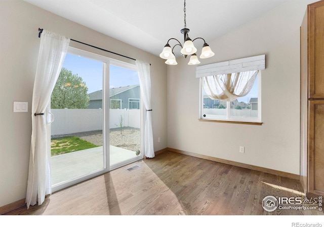 7056 Langland St, Wellington, CO 80549 - unfurnished dining area with a chandelier, plenty of natural light, wood finished floors, and baseboards