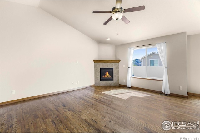 7056 Langland St, Wellington, CO 80549 - unfurnished living room featuring a fireplace, wood finished floors, baseboards, and lofted ceiling