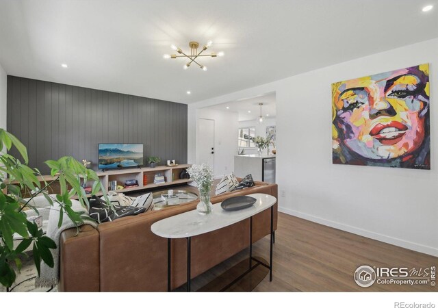 living room with recessed lighting, baseboards, a notable chandelier, and wood finished floors
