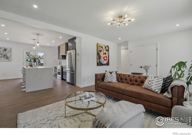 living room featuring an inviting chandelier, baseboards, recessed lighting, and dark wood-style flooring