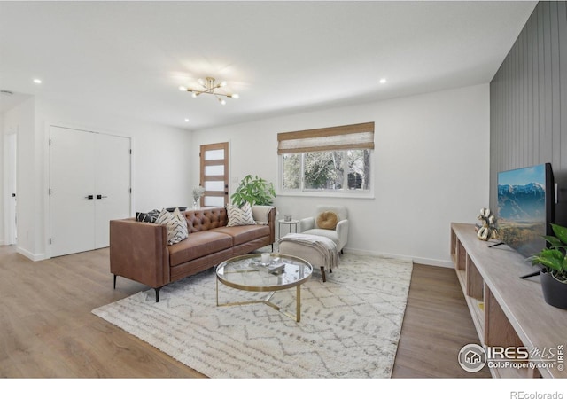 living area with baseboards, recessed lighting, and light wood-style flooring