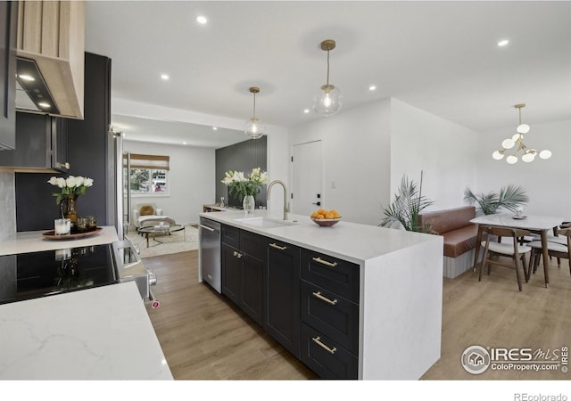kitchen featuring recessed lighting, a sink, light wood finished floors, and open floor plan