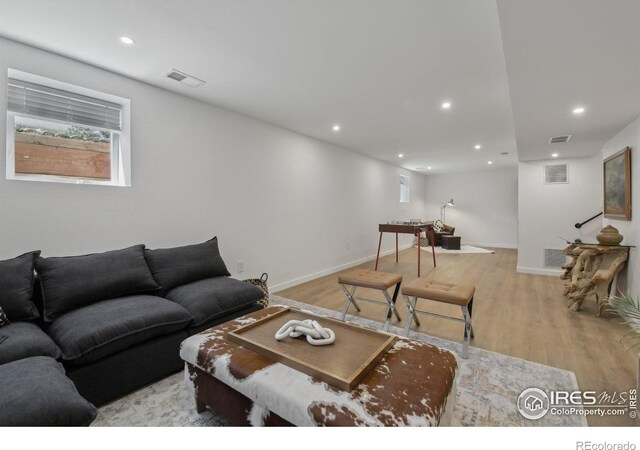 living room with recessed lighting, baseboards, visible vents, and light wood-style floors
