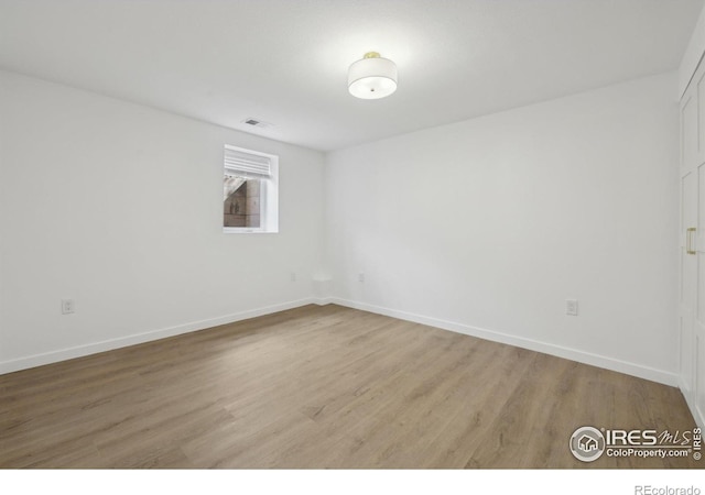 unfurnished room featuring baseboards, visible vents, and light wood-type flooring
