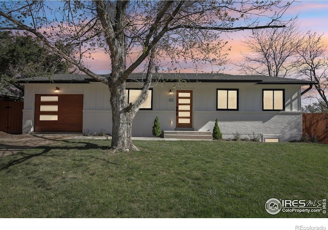 view of front facade with fence, a front lawn, a garage, board and batten siding, and driveway