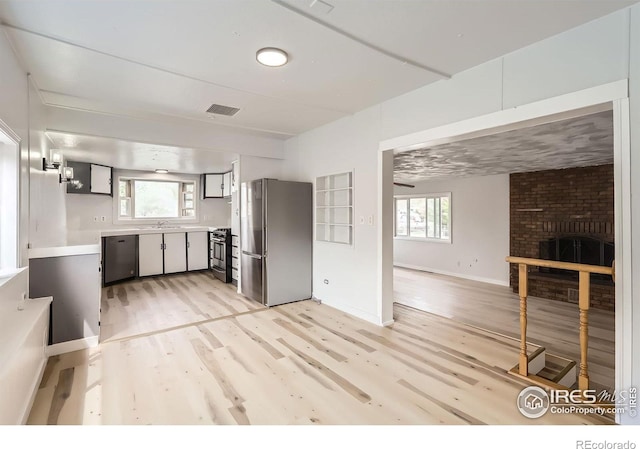 214 2nd St, Frederick, CO 80530 - kitchen featuring visible vents, a fireplace, light wood-style flooring, light countertops, and appliances with stainless steel finishes