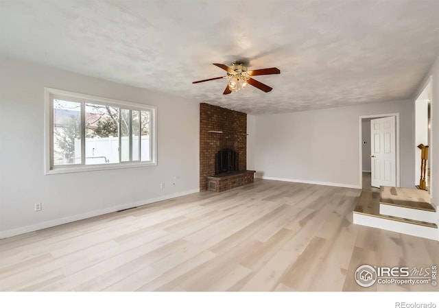 214 2nd St, Frederick, CO 80530 - unfurnished living room with a fireplace, ceiling fan, baseboards, and wood finished floors