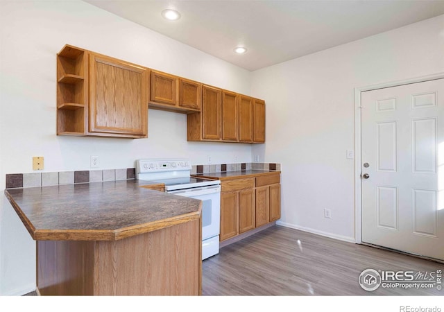 kitchen with brown cabinetry, open shelves, dark countertops, light wood-style floors, and white electric range