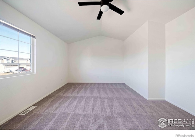spare room with visible vents, lofted ceiling, baseboards, ceiling fan, and carpet flooring