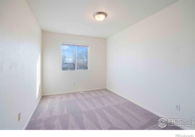 unfurnished room with carpet flooring, baseboards, and visible vents
