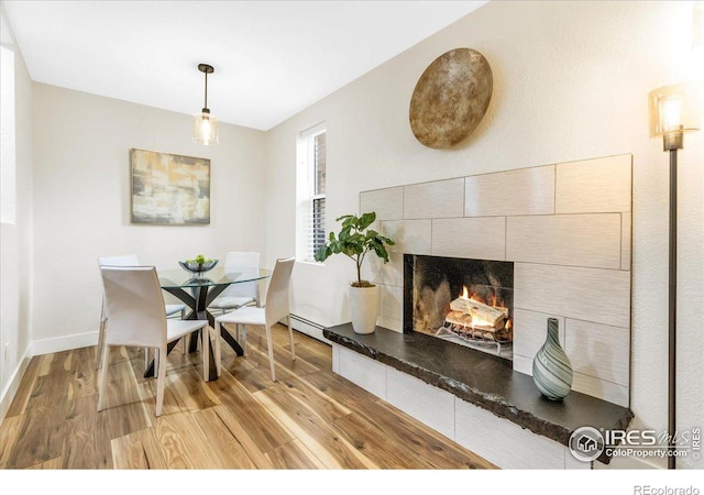 3035 Oneal Pkwy Unit 19, Boulder, CO 80301 - dining area featuring light wood-type flooring, a tile fireplace, baseboard heating, and baseboards