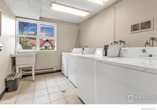 3035 Oneal Pkwy Unit 19, Boulder, CO 80301 - community laundry with washing machine and clothes dryer, a baseboard heating unit, light tile patterned floors, and baseboards