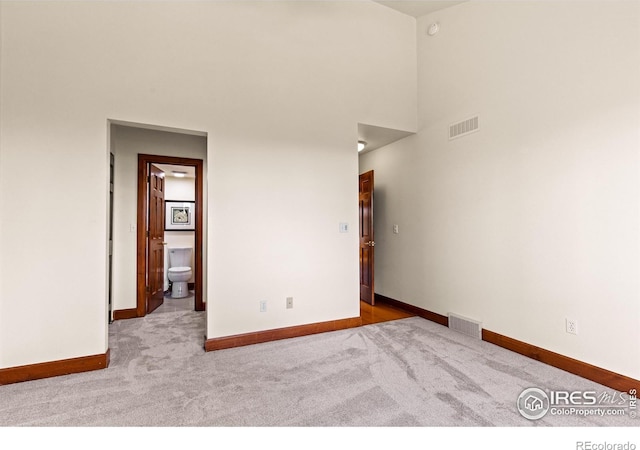 2499 Powderhorn Ln, Boulder, CO 80305 - spare room featuring carpet floors, baseboards, visible vents, and a towering ceiling