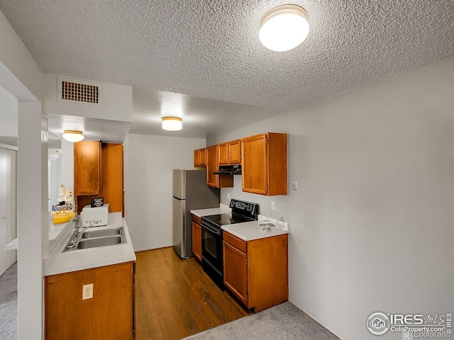 1094 S Dearborn St Unit 301, Aurora, CO 80012 - kitchen with electric range, a sink, light countertops, under cabinet range hood, and a textured ceiling