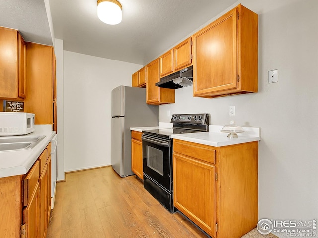 1094 S Dearborn St Unit 301, Aurora, CO 80012 - kitchen featuring under cabinet range hood, white appliances, light wood finished floors, light countertops, and a sink