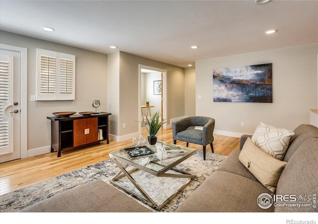 living room featuring recessed lighting, baseboards, and wood finished floors