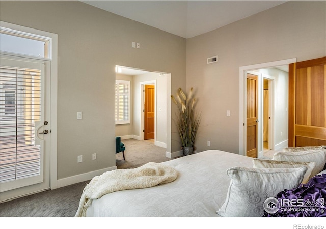 bedroom with visible vents, a towering ceiling, access to exterior, baseboards, and carpet flooring