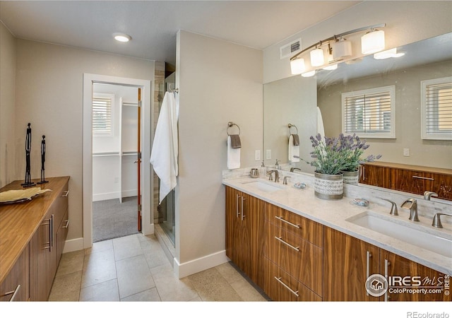 full bath with visible vents, a sink, baseboards, and a shower stall