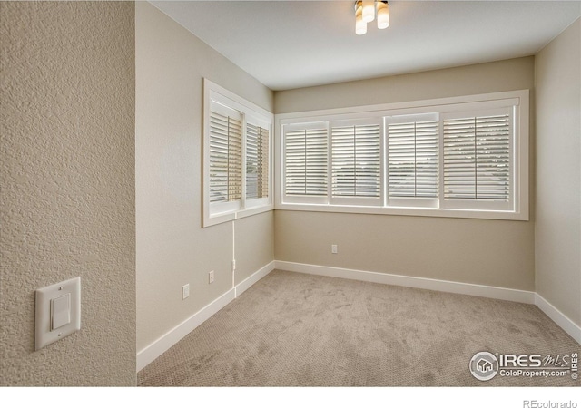 unfurnished room featuring carpet flooring and baseboards