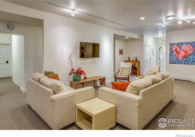 living room with carpet floors, rail lighting, a baseboard heating unit, and baseboards