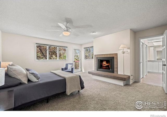 4950 Sundance Sq, Boulder, CO 80301 - bedroom with carpet, access to outside, a tiled fireplace, a textured ceiling, and ceiling fan