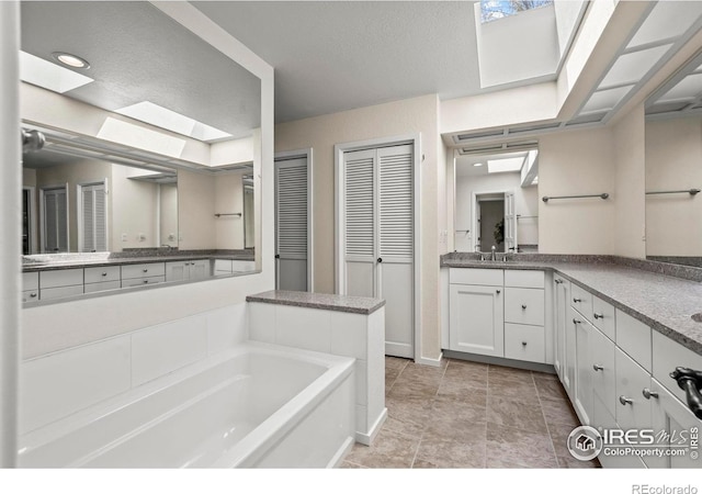 4950 Sundance Sq, Boulder, CO 80301 - bathroom with a skylight, a closet, a bath, and vanity