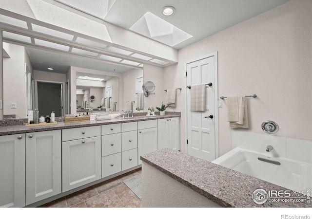 4950 Sundance Sq, Boulder, CO 80301 - bathroom with a skylight, double vanity, a garden tub, and recessed lighting