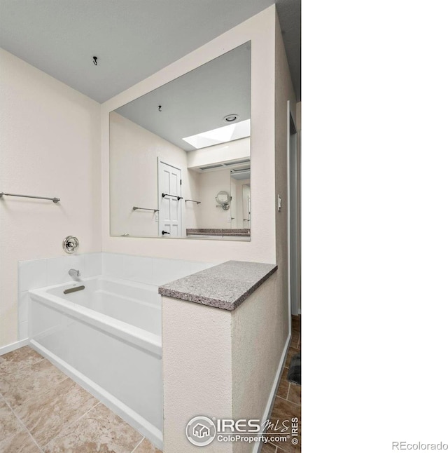 4950 Sundance Sq, Boulder, CO 80301 - bathroom featuring a bath, a skylight, and baseboards