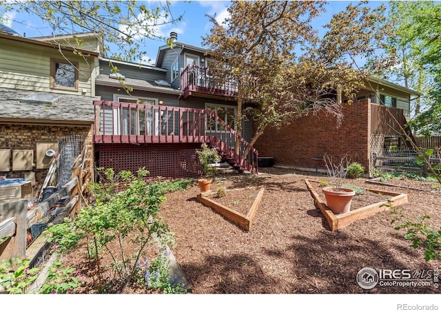 4950 Sundance Sq, Boulder, CO 80301 - rear view of house with a vegetable garden, stairs, a wooden deck, and fence