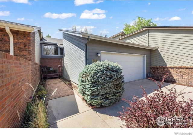 4950 Sundance Sq, Boulder, CO 80301 - view of home's exterior featuring fence, concrete driveway, and a garage