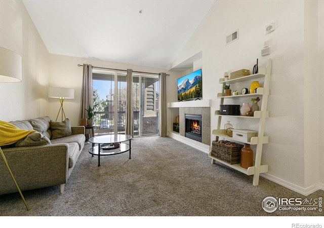 carpeted living area featuring a tiled fireplace, visible vents, baseboards, and lofted ceiling