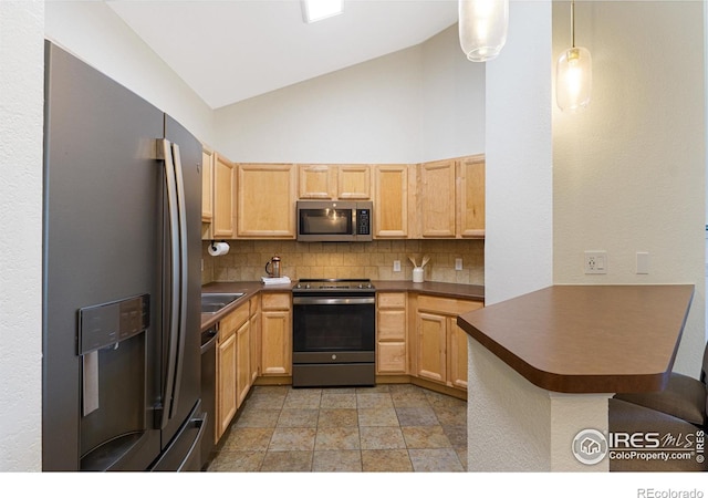 kitchen with a peninsula, dark countertops, stainless steel appliances, light brown cabinets, and decorative backsplash
