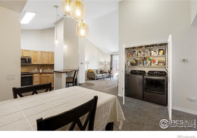 carpeted dining space featuring washing machine and dryer, baseboards, and high vaulted ceiling