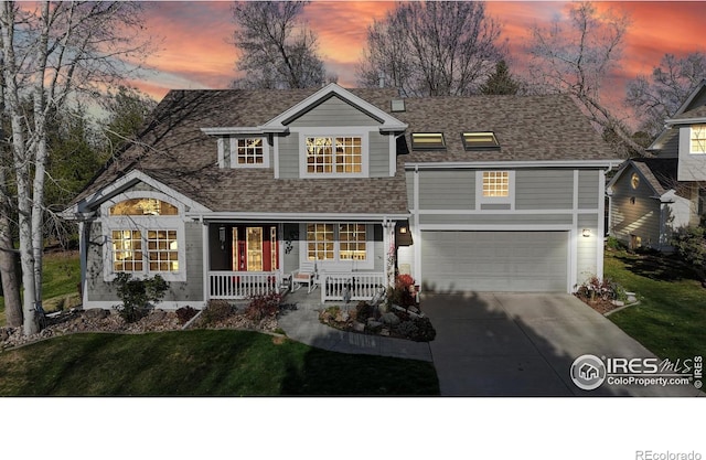 back of property featuring an attached garage, a yard, covered porch, and concrete driveway