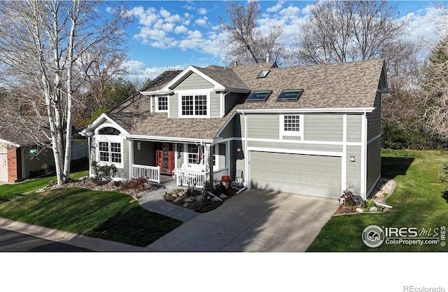 traditional-style home with roof with shingles, a garage, a front yard, covered porch, and driveway