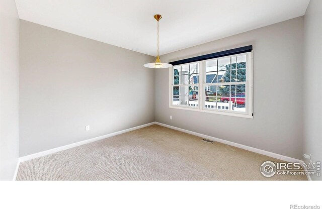 unfurnished room with visible vents, carpet, and baseboards